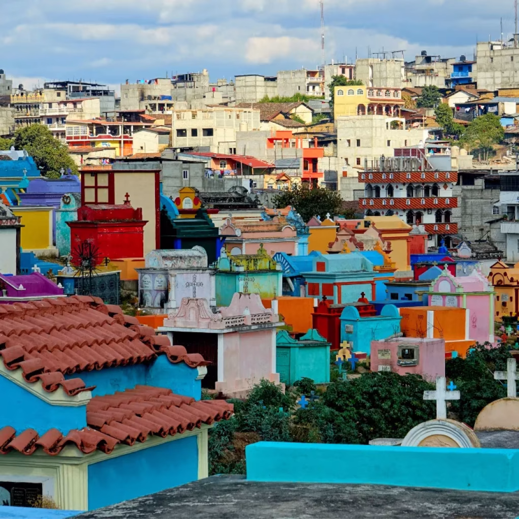 Inexpensive Places to Travel, Vibrant cemetery with colorful tombs and buildings in Guatemala City.