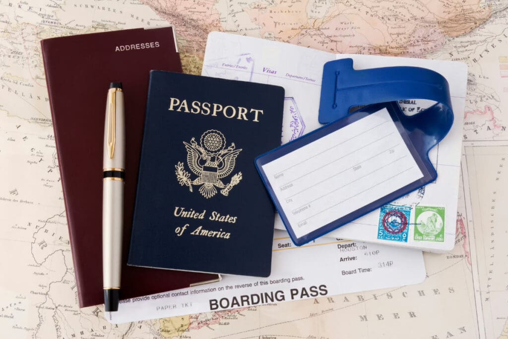 Travel on a Whim, A United States passport, boarding pass, pen, and travel documents arranged on a map.
