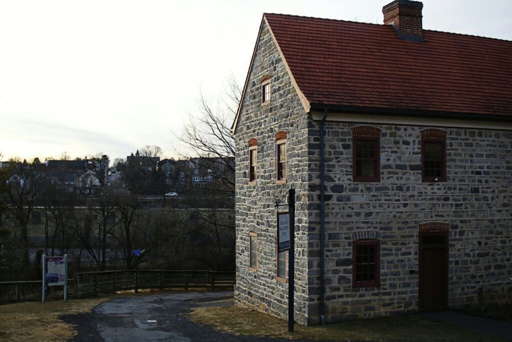 Stone house with red roof in landscape.